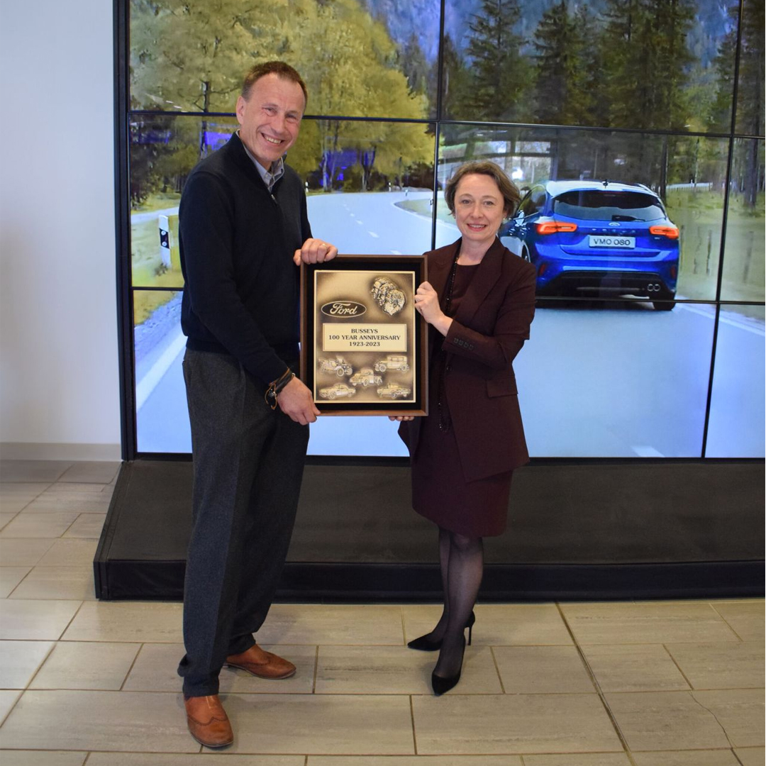 Ford UK President Lisa Brankin presents Paul Bussey with a plaque to mark 100 years as a Ford Dealer